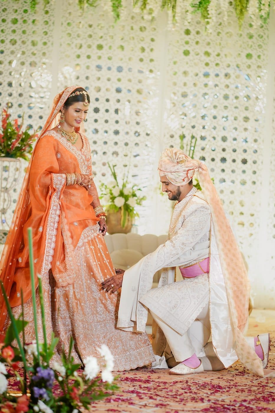The groom kneeling before the bride during a ceremony