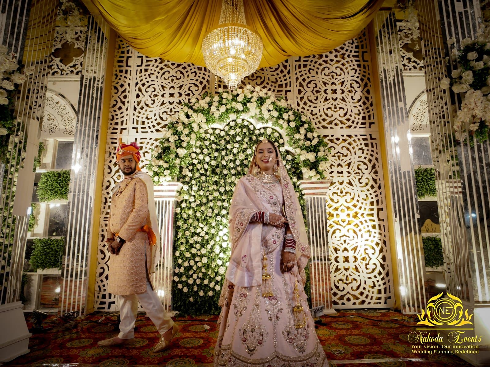 A couple mid-ceremony beneath a floral canopy