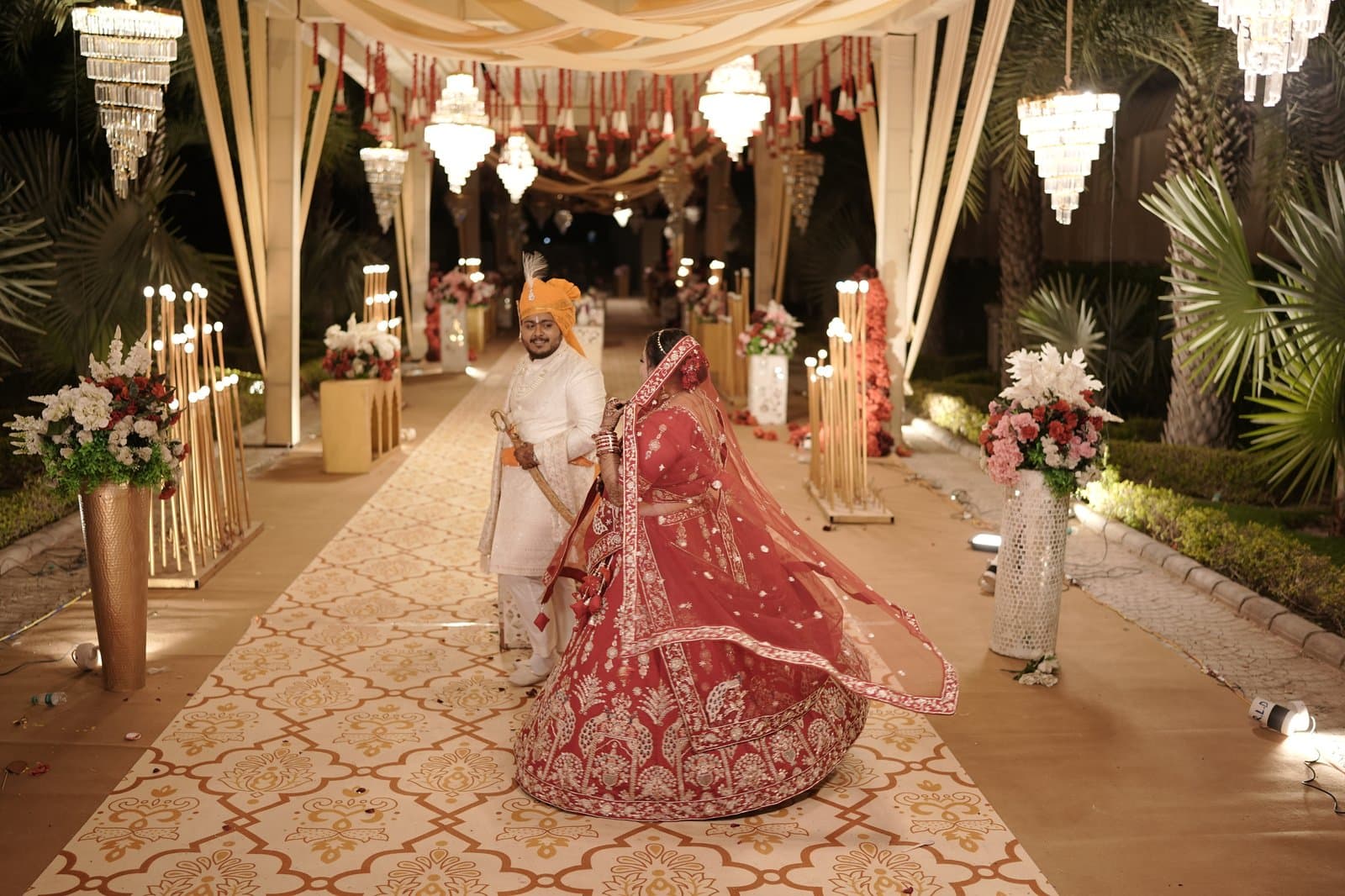 A bride and groom walking a candlelit aisle